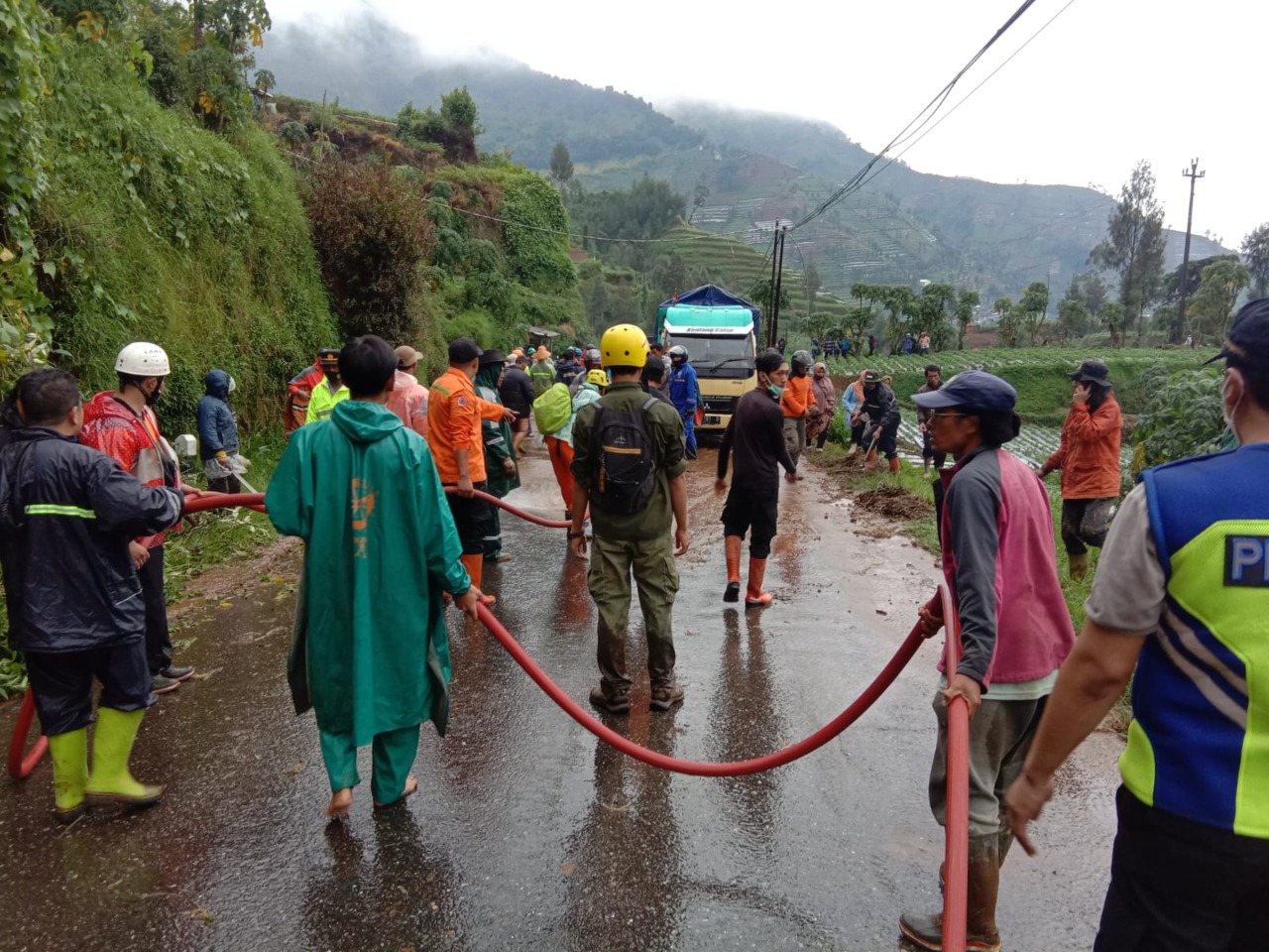 Para warga bersama tim gabungan bekerjasama untuk melakukan pembersihan jalan usai terjadi longsor di Kecamatan Kejajar, Wonosobo, Rabu (9/2). (BPBD Kabupaten Wonosobo)